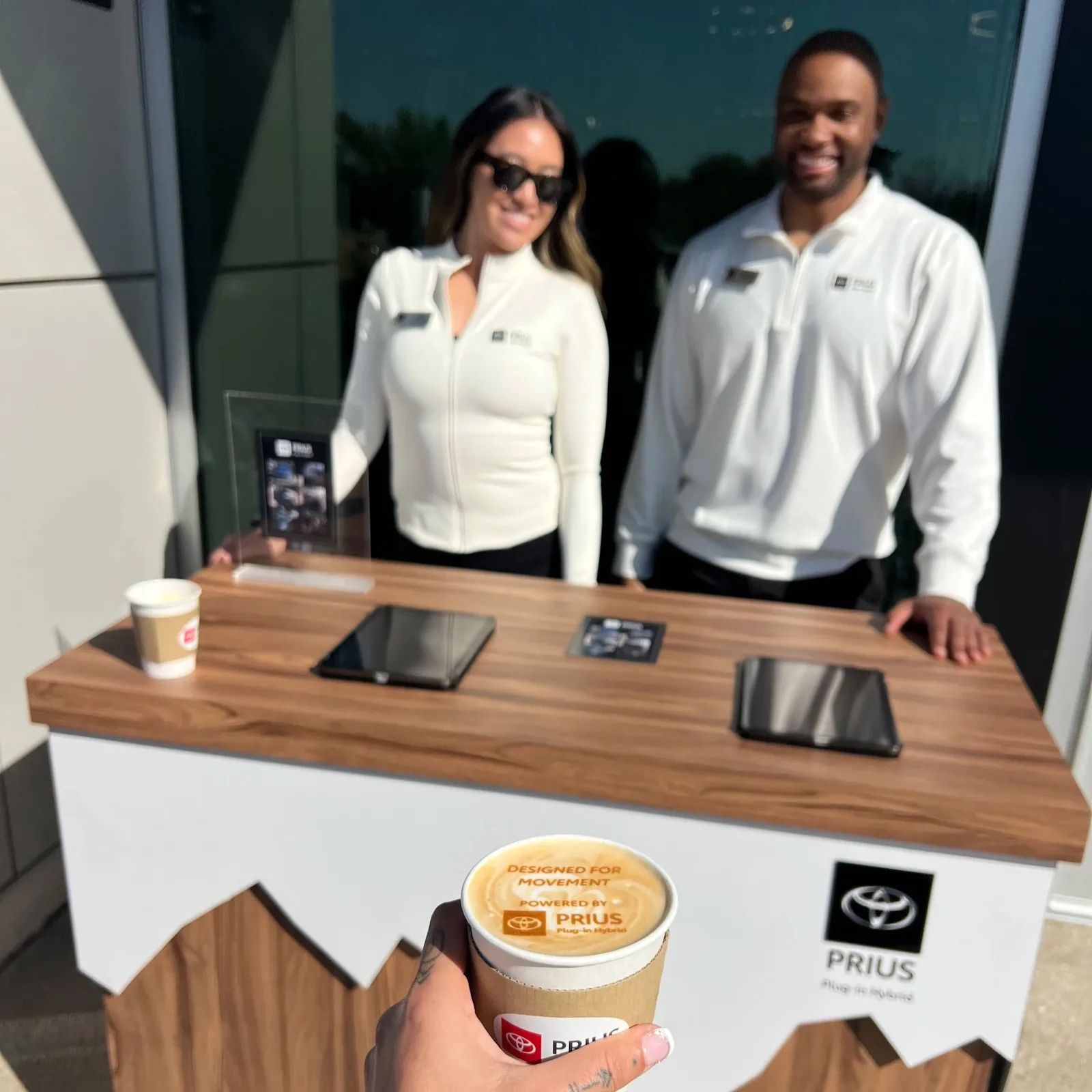 Custom-branded white coffee cart at a Toyota brand activation with a logo-printed latte