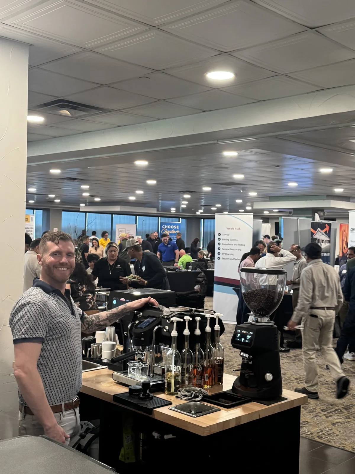 Barista serving espresso drinks from a mobile coffee cart at a busy Dallas expo