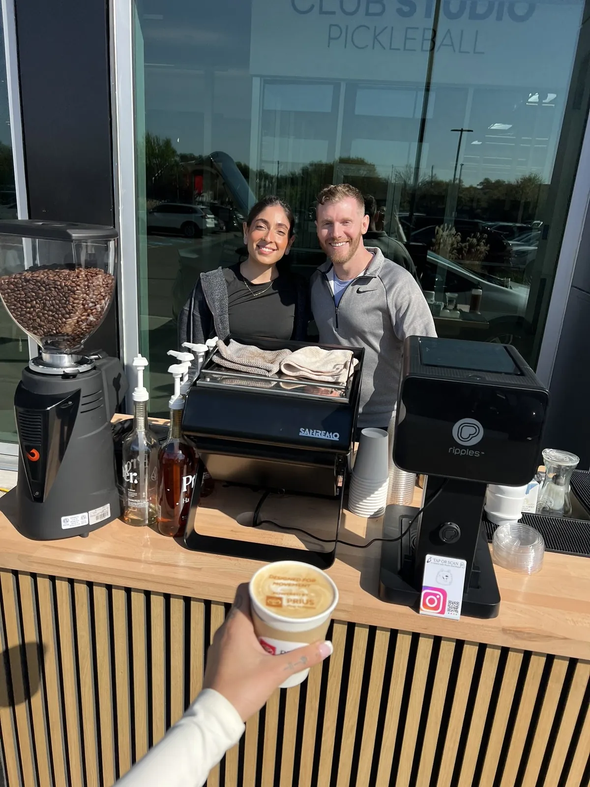 Guests at a corporate event in Dallas holding a latte with a printed logo from the coffee cart